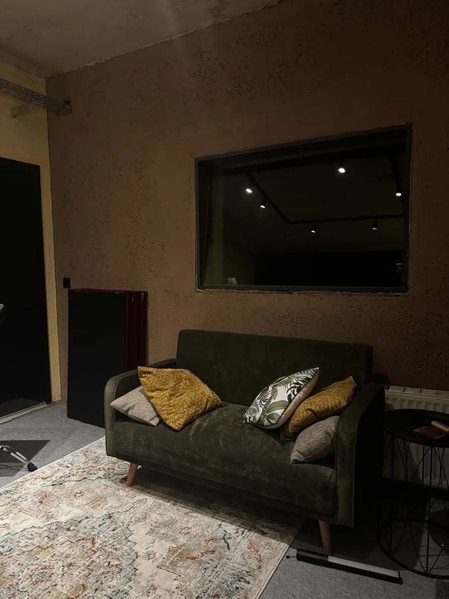 Lounge-Bereich mit Couch und Blick zur Regie im MJM Studio